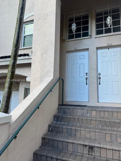 Exterior view of a building entrance with stone stairs leading to two white doors — 5650 NW 115th Ct # 203, Doral FL 33178, DORAL, FL