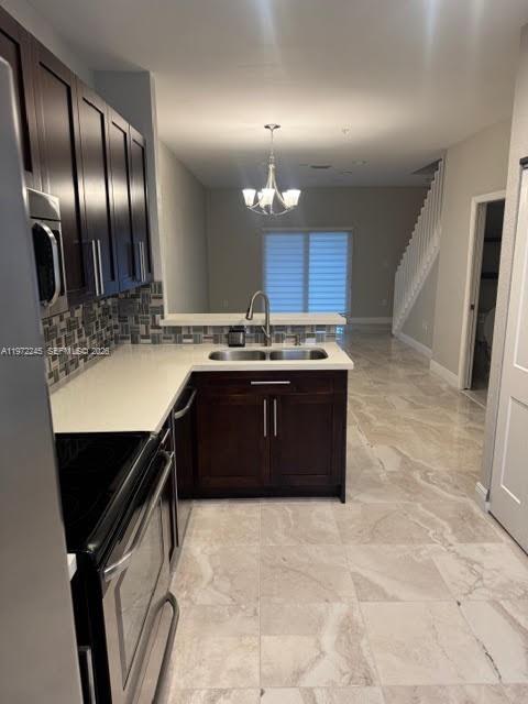 A kitchen with dark wood cabinets, white countertops, and tile flooring overlooks a living area — 5650 NW 115th Ct # 203, Doral FL 33178, DORAL, FL