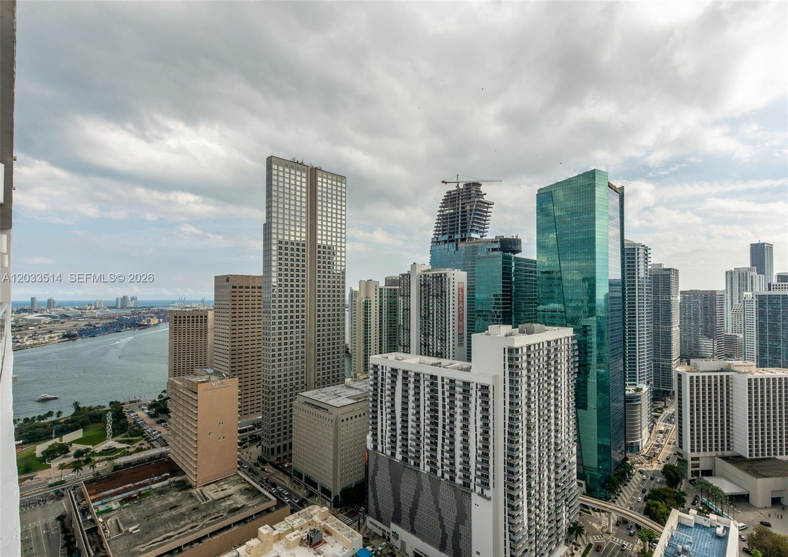 An elevated view of the Miami skyline featuring various skyscrapers, a waterway, and a port — 151 SE 1st St # 807, Miami FL 33131, MIAMI, FL