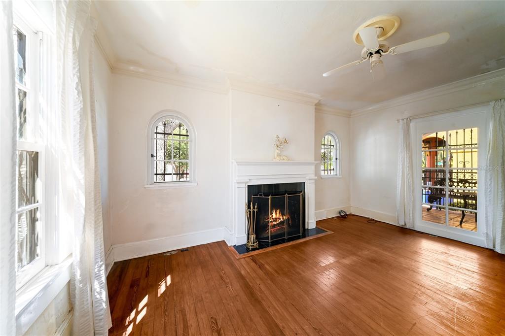 A living room with hardwood floors, a fireplace, arched windows, and a glass door — 411 BURNS COURT, SARASOTA, FL