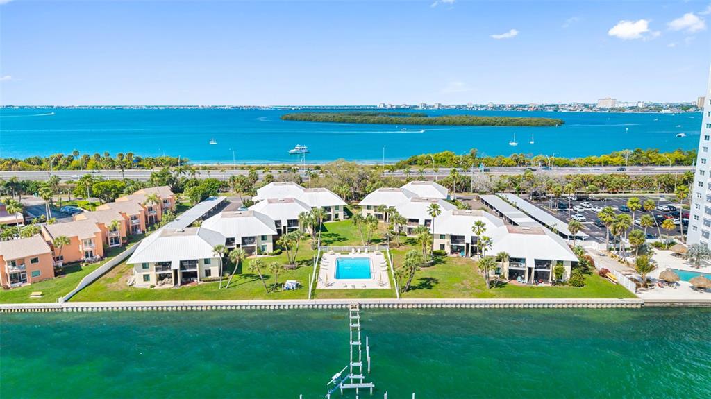 An aerial view of a waterfront condominium complex with a swimming pool and private dock — 7300 SUNSHINE SKYWAY LANE S UNIT 210, ST PETERSBURG, FL