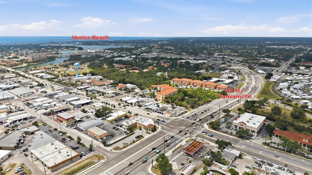 An aerial view shows a commercial building circled near a major intersection and highway — 629 E VENICE AVENUE, VENICE, FL