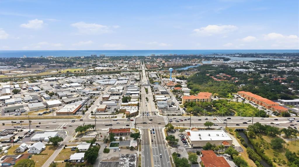 An aerial view shows a commercial area with a major road leading toward the ocean — 629 E VENICE AVENUE, VENICE, FL