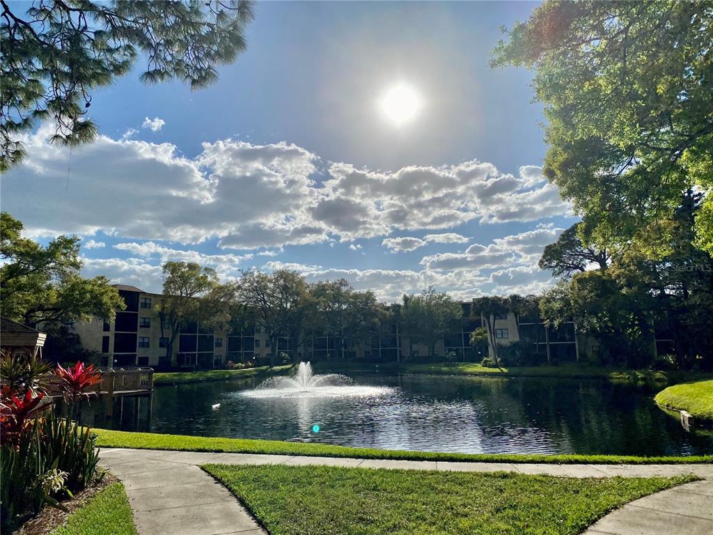 A pond with a fountain sits in front of a multi-story apartment building — 315 30TH AVENUE W UNIT B305, BRADENTON, FL
