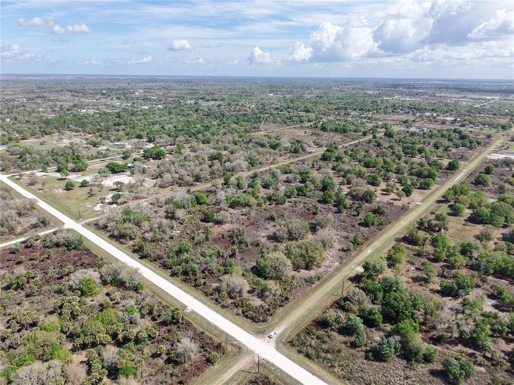 An aerial view shows a large, undeveloped plot of land bordered by two dirt roads — 20755 NW 262ND STREET, OKEECHOBEE, FL