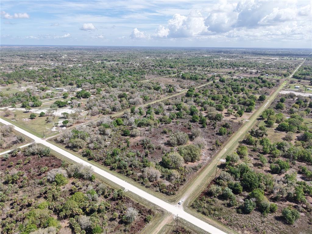 An aerial view shows a large, undeveloped plot of land bordered by two dirt roads — 20755 NW 262ND STREET, OKEECHOBEE, FL