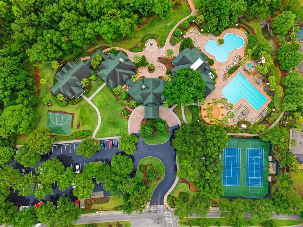 An aerial view shows a clubhouse with two swimming pools, tennis courts, and a basketball court — 21347 MORNING MIST WAY, LAND O LAKES, FL
