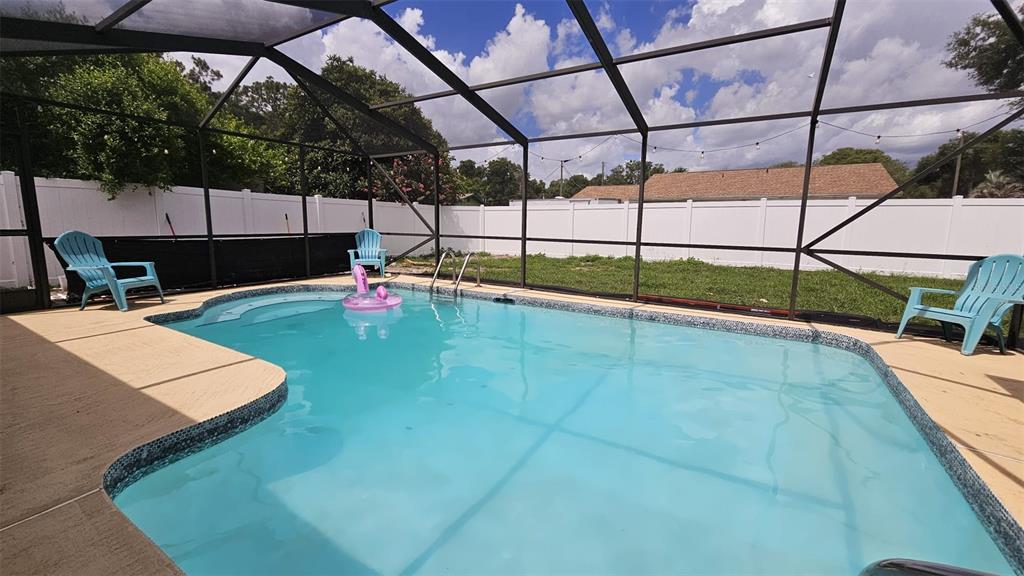A single-story house with a light-colored stucco exterior, dark shutters, and a stone-bordered garden bed — 729 SINCLAIR TERRACE, INVERNESS, FL