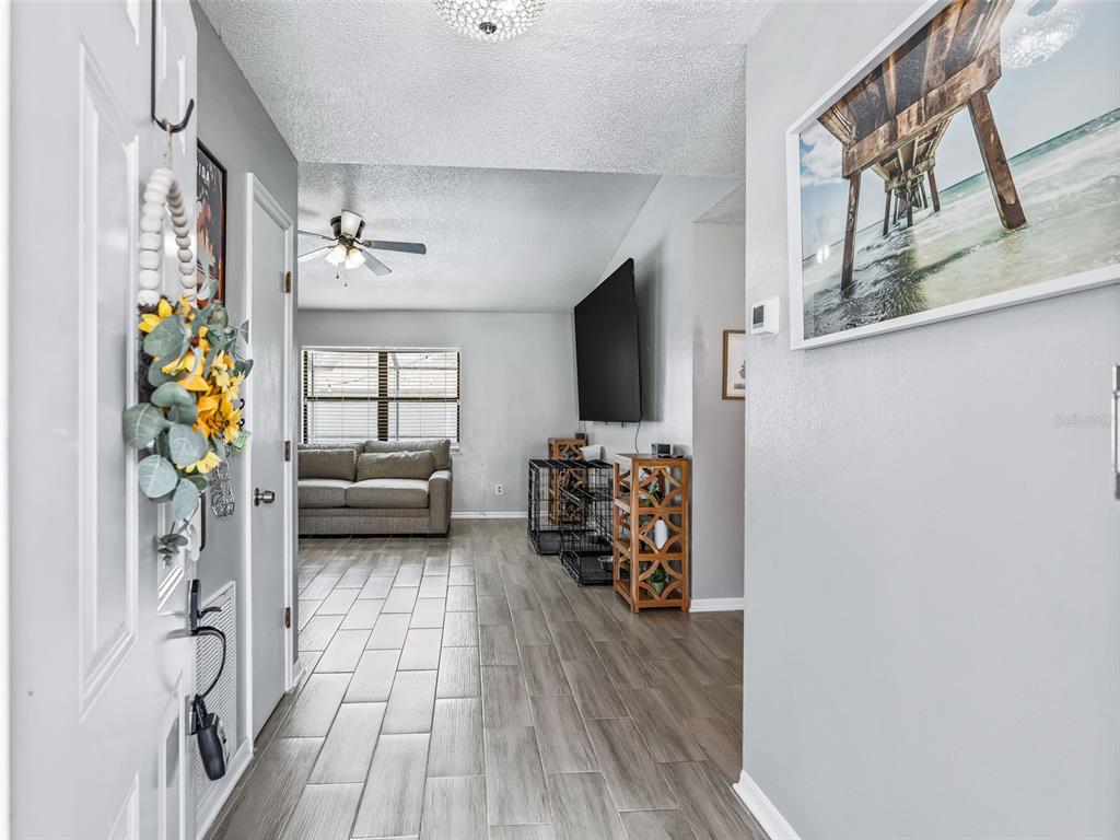 A view from an entryway looking into a living room with wood-look tile flooring — 729 SINCLAIR TERRACE, INVERNESS, FL