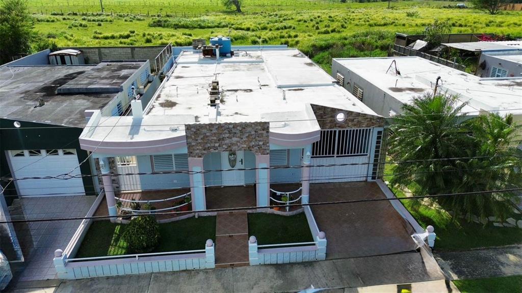 An aerial view shows a light blue single-story house with a flat roof and driveway — A11 BO ISLOTE, COSTA ATLANTICO, ARECIBO, PR
