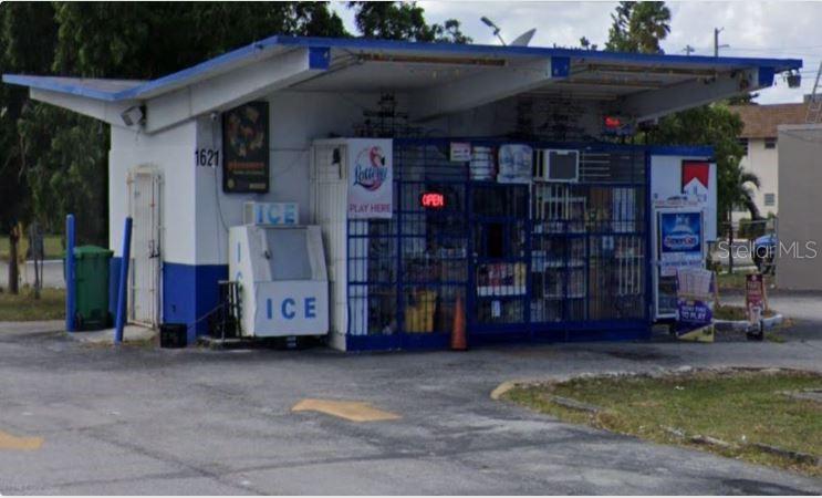 A small commercial building with a blue and white exterior and a large ice machine — 1621 N CYPRESS ROAD, POMPANO BEACH, FL