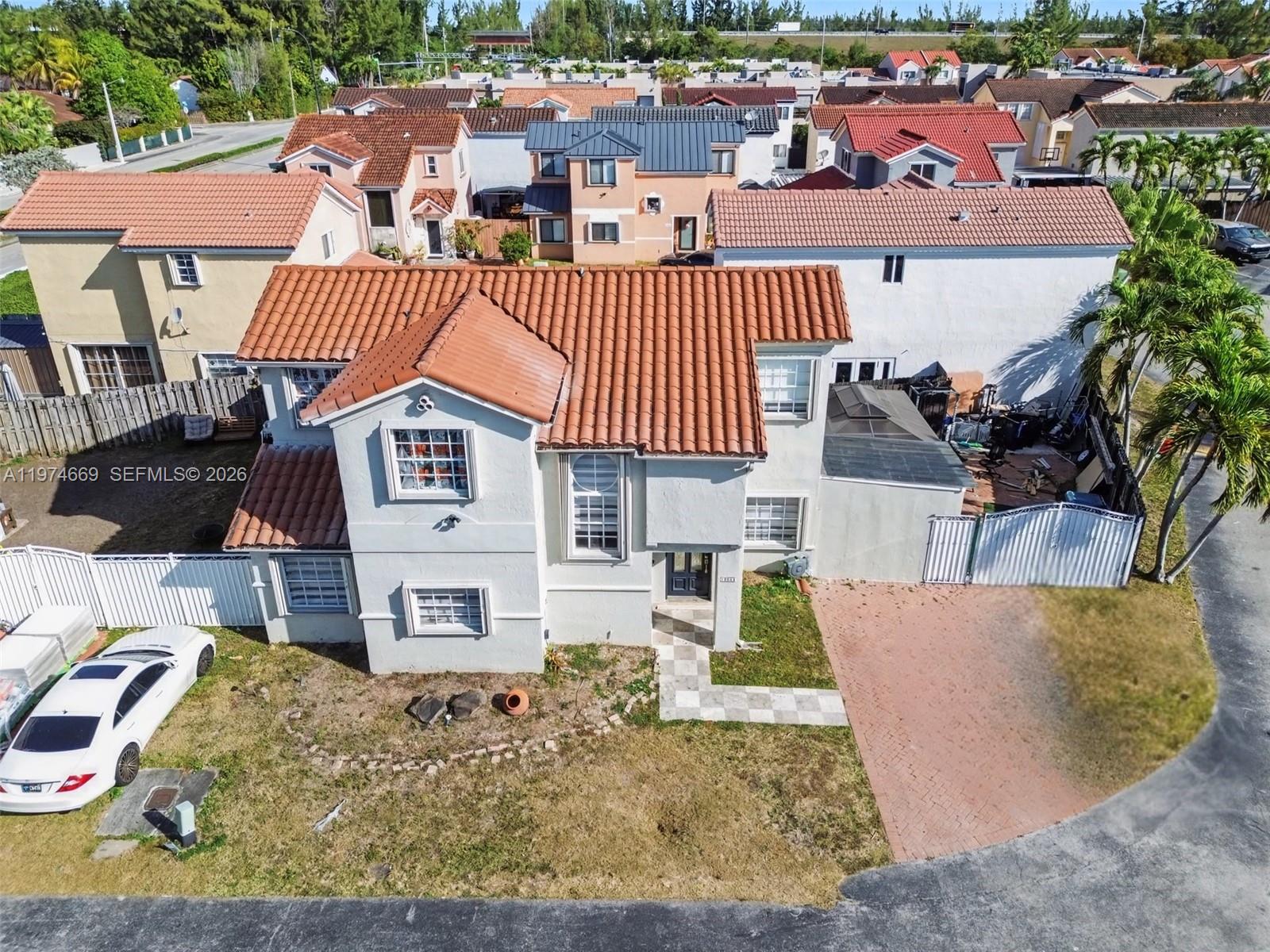 An aerial view of a two-story house with a red tile roof and paved driveway — 12689 NW 10th Way, Miami FL 33182, MIAMI, FL