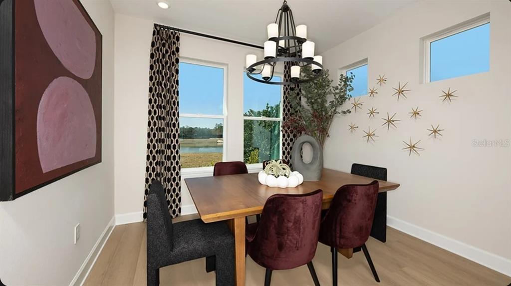 A dining room features a wooden table, velvet chairs, a chandelier, and wall-mounted star decorations — 14224 DUNLIN AVENUE, PUNTA GORDA, FL