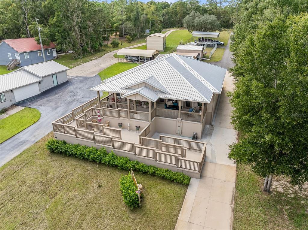An aerial view of a house with a metal roof and a large multi-level deck — 8449 LILLY LAKE ROAD, MELROSE, FL