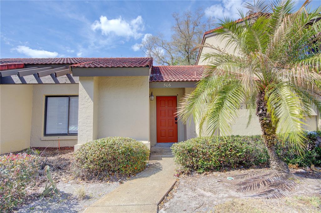 A tan stucco building with a red tile roof and a red front door — 506 CLUB DRIVE, WINTER SPRINGS, FL