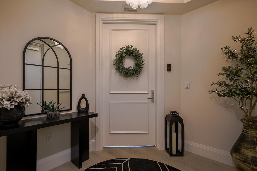 A white front door with a wreath stands in a foyer with a console table — 2910 W BARCELONA STREET UNIT 604, TAMPA, FL