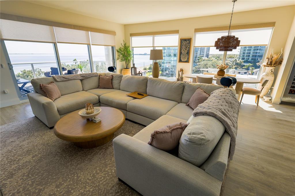 A spacious living room features a large sectional sofa, a round coffee table, and floor-to-ceiling windows — 2910 W BARCELONA STREET UNIT 604, TAMPA, FL