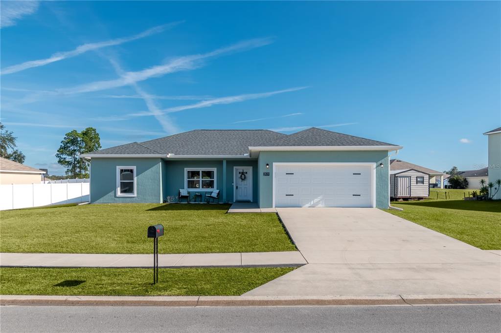 A single-story teal house with a two-car garage and a front lawn — 2839 NE 43RD ROAD, OCALA, FL