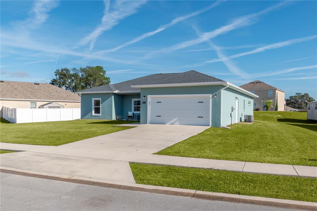 A single-story light blue house with a two-car garage and a concrete driveway — 2839 NE 43RD ROAD, OCALA, FL