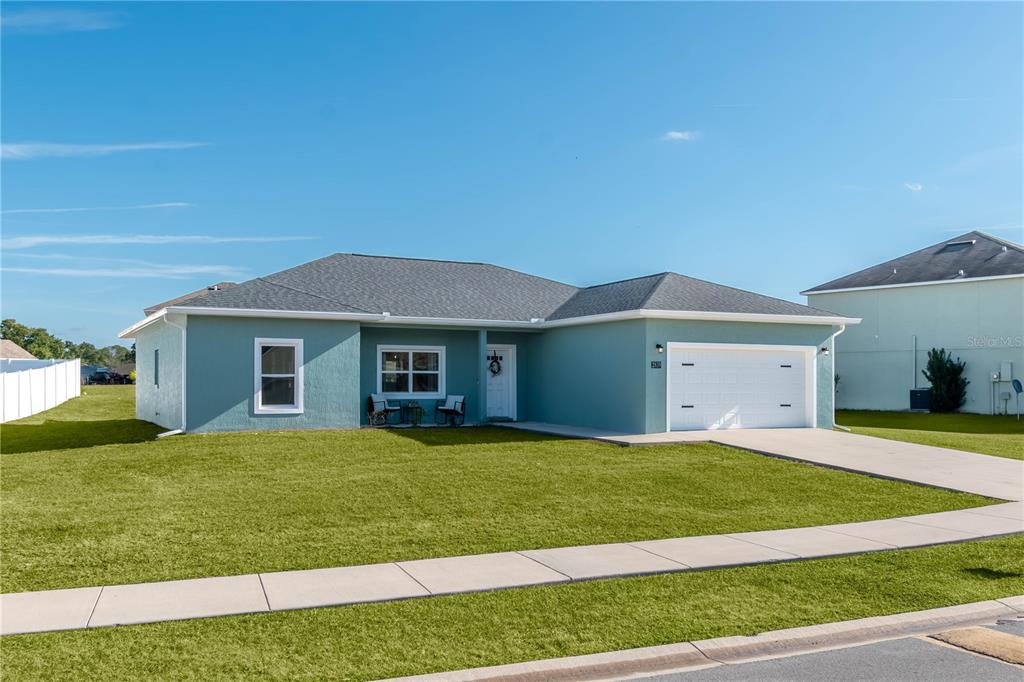A single-story, light blue house with a white garage and a front lawn — 2839 NE 43RD ROAD, OCALA, FL