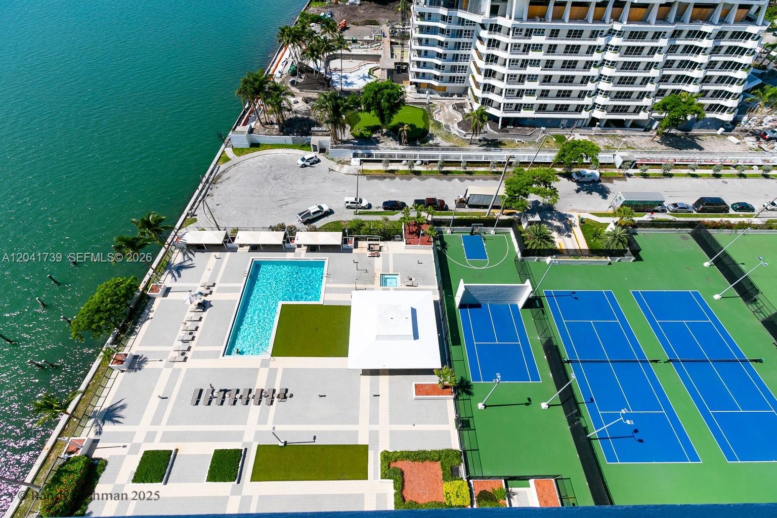 An aerial view shows a swimming pool, tennis courts, and a basketball court near water — 600 NE 36th St # 1820, Miami FL 33137, MIAMI, FL