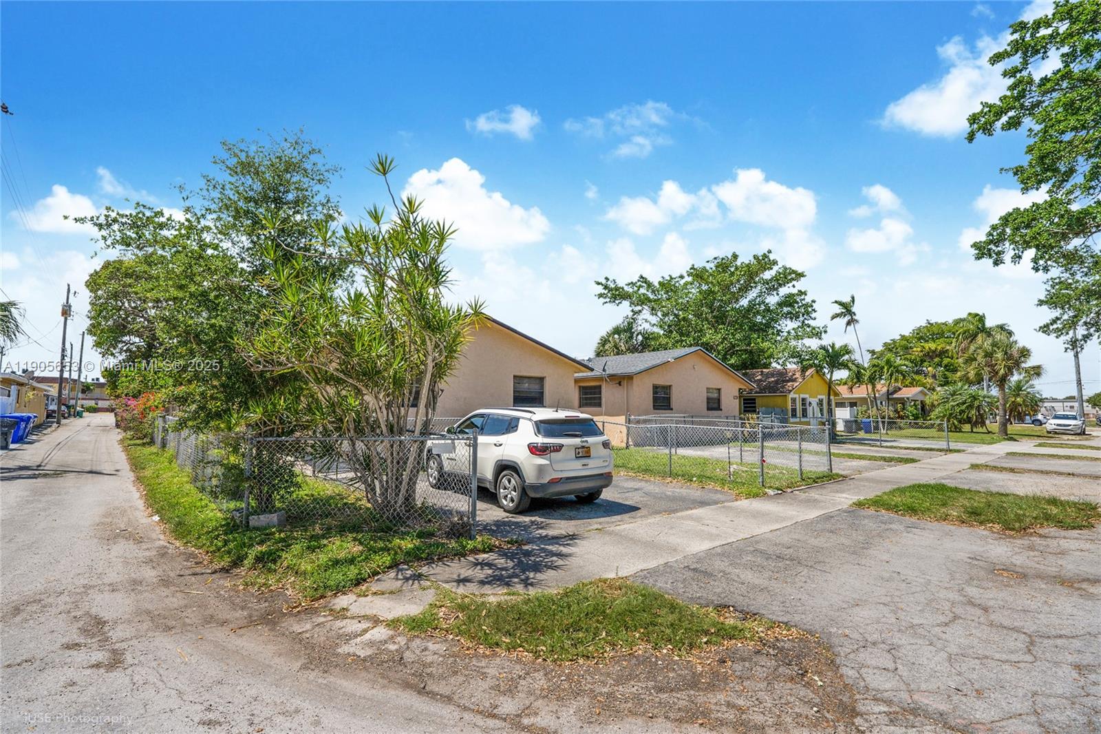 A white SUV is parked in the driveway of a single-story house with chain-link fencing — 1734 N 16th Ct, Hollywood FL 33020, HOLLYWOOD, FL