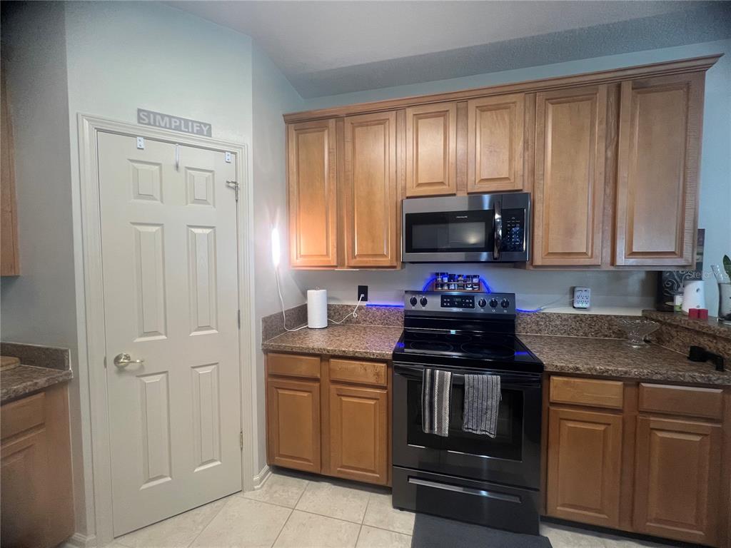An exterior view of a multi-unit townhouse complex with attached garages and a shared driveway — 332 WOODED CROSSING CIRCLE, ST AUGUSTINE, FL