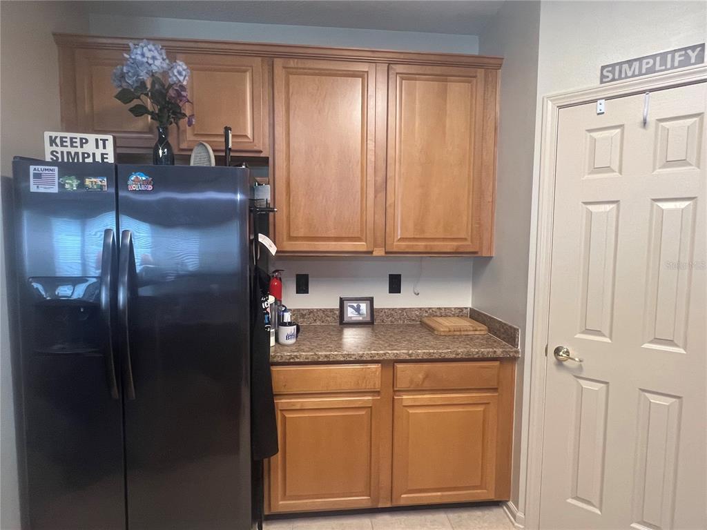 A kitchen features wood cabinets, granite countertops, a black stove, and a microwave — 332 WOODED CROSSING CIRCLE, ST AUGUSTINE, FL