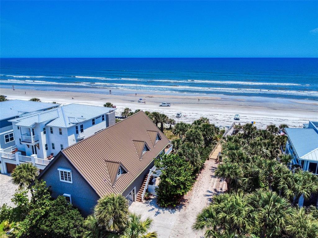 An aerial view shows a beach house with a brown metal roof near the ocean — 1913 HILL STREET UNIT 2, NEW SMYRNA BEACH, FL