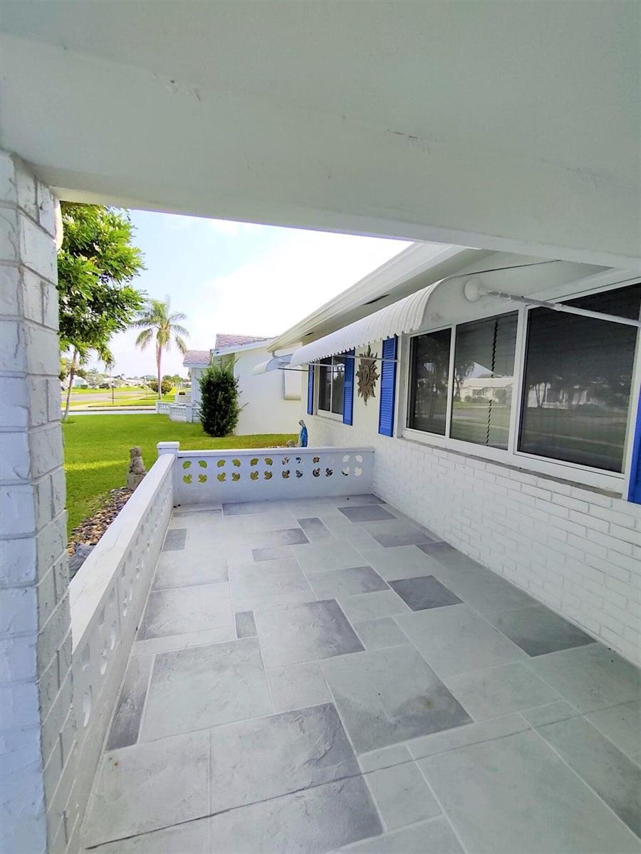 A covered patio with light gray tiled flooring and a decorative white concrete block wall — 1826 SW Congress Boulevard, Boynton Beach FL 33426, BOYNTON BEACH, FL