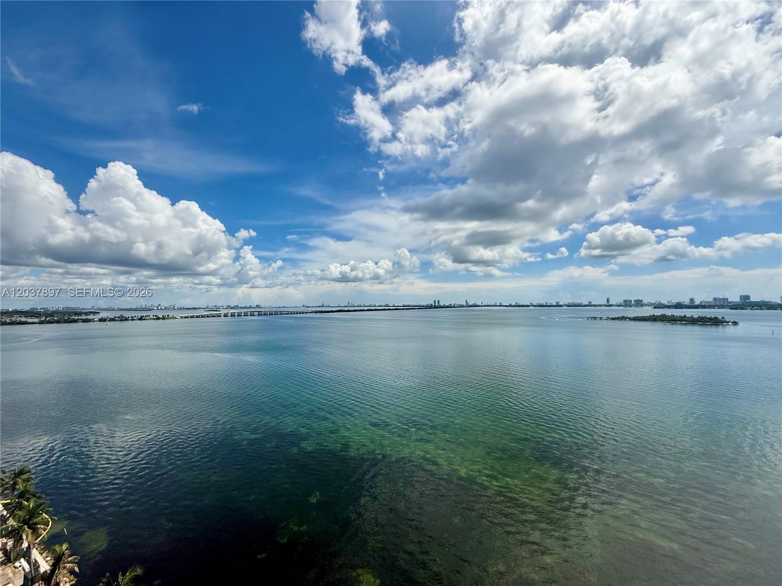 An elevated view of a large bay with a long bridge and distant city skyline — 700 NE 24th St # 1002, Miami FL 33137, MIAMI, FL