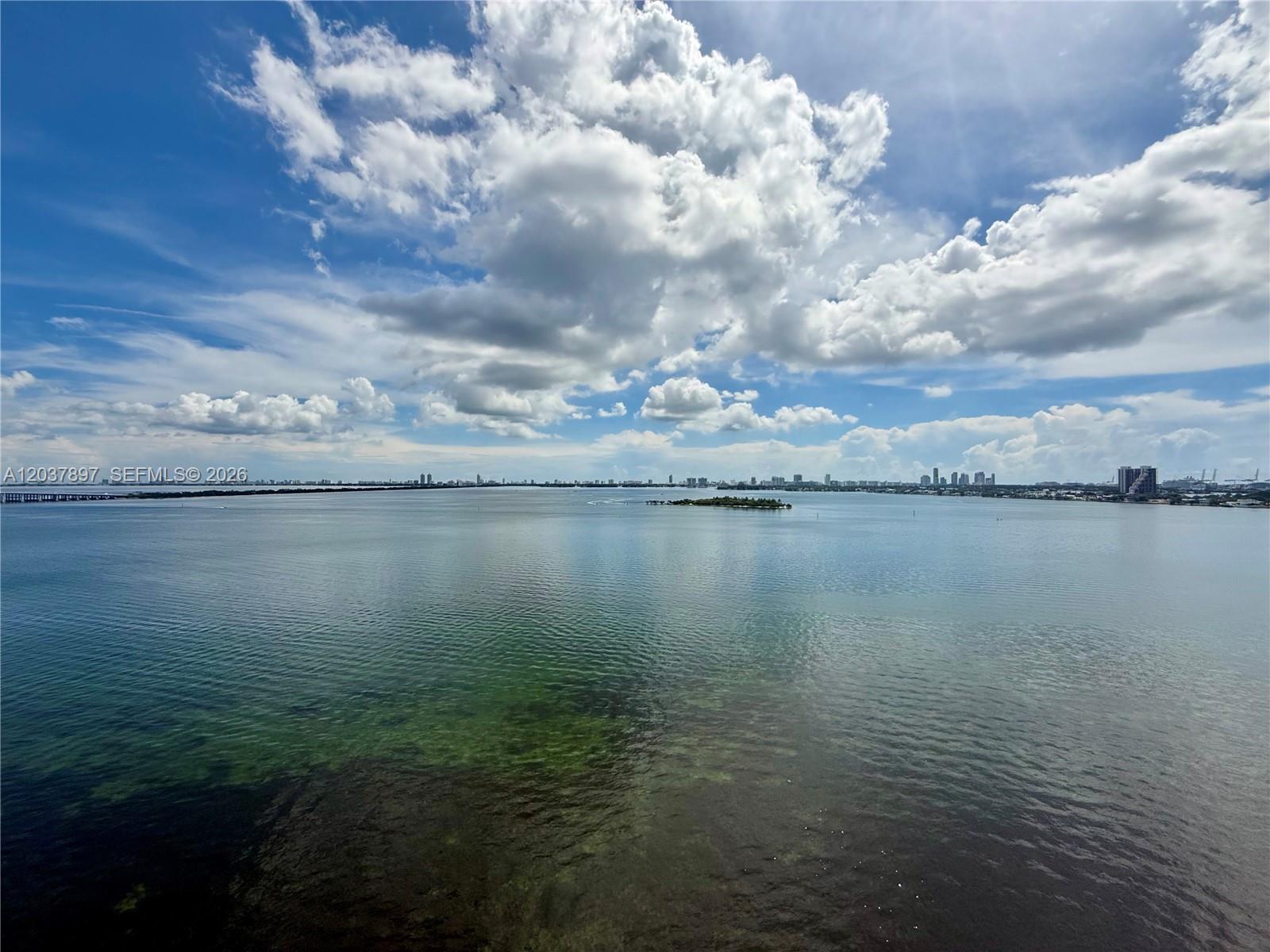 A wide-angle view of a calm bay with a small island under a cloudy sky — 700 NE 24th St # 1002, Miami FL 33137, MIAMI, FL