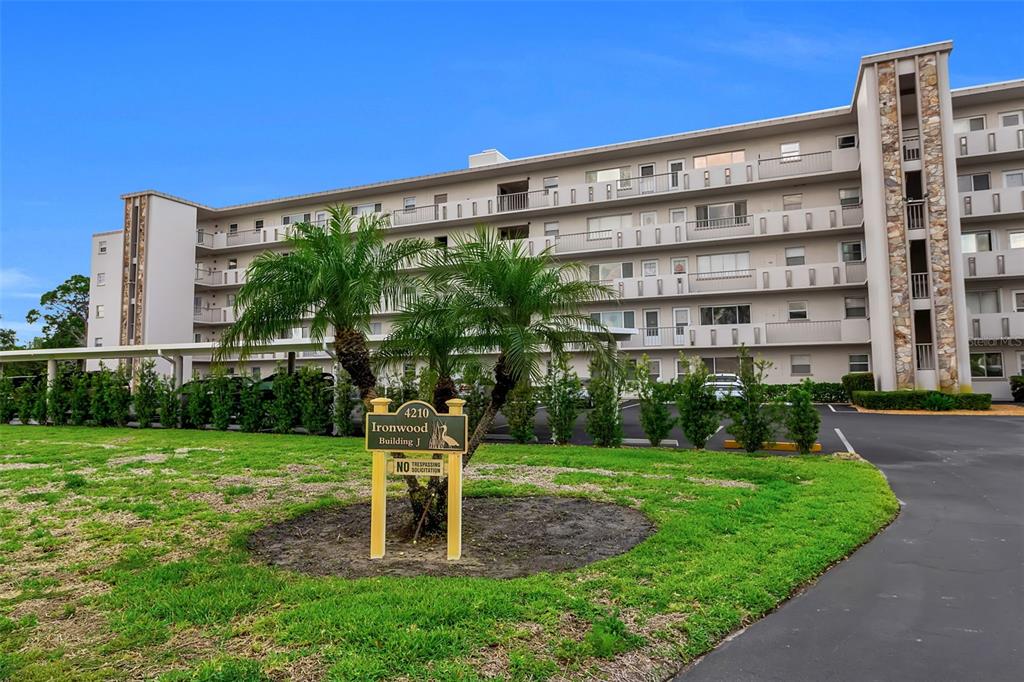 A multi-story apartment building with a palm tree and signage in the foreground — 4210 IRONWOOD CIRCLE UNIT 403J, BRADENTON, FL