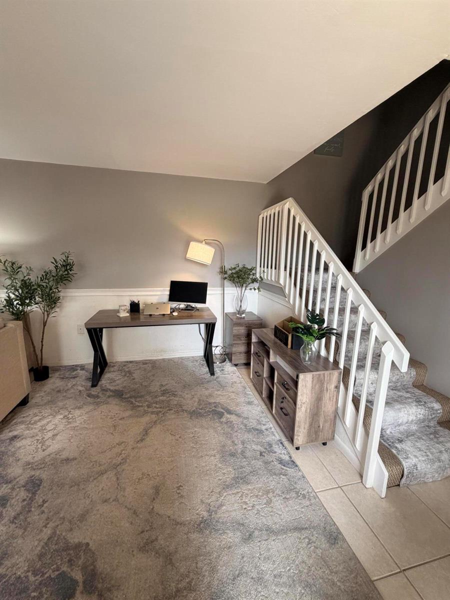 A home office area features a desk, a floor lamp, and stairs with white railings — 812 8th Way, West Palm Beach FL 33407, WEST PALM BEACH, FL
