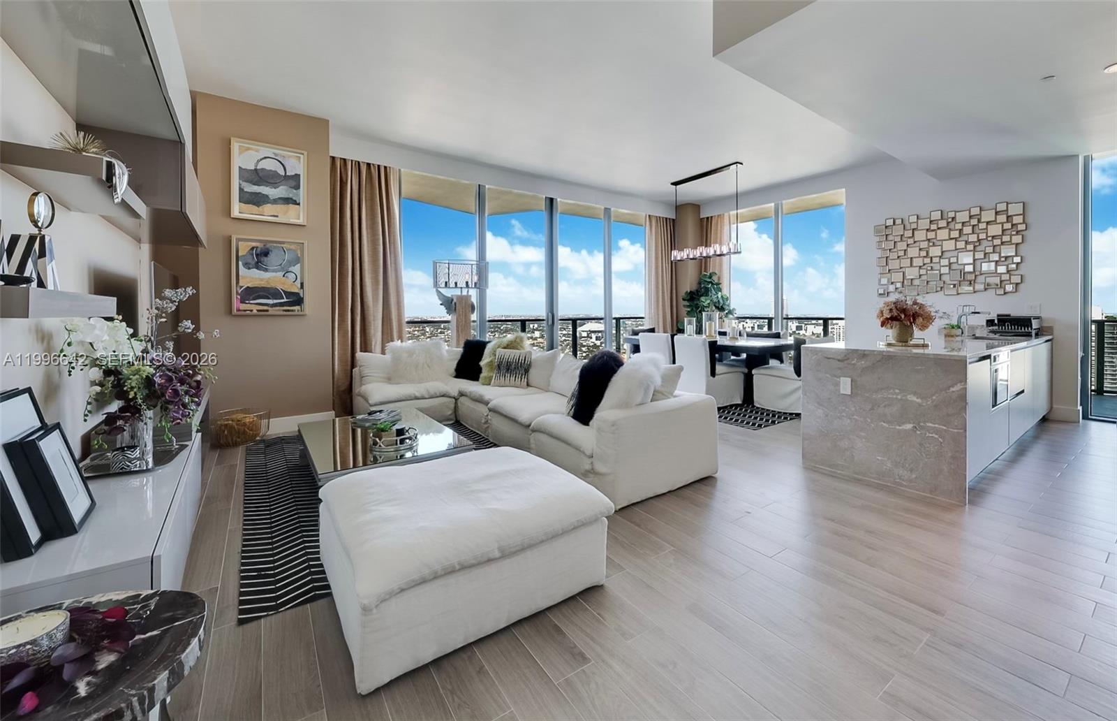 A modern open-concept living and dining area features floor-to-ceiling windows with panoramic city views — 1300 S Miami Ave, Miami FL 33130, MIAMI, FL
