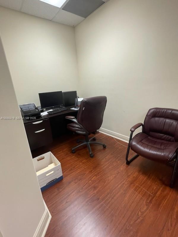 A small office features a dark wood desk, two leather chairs, and wood-look flooring — 12900 SW 128th St # 104, Miami FL 33186, MIAMI, FL