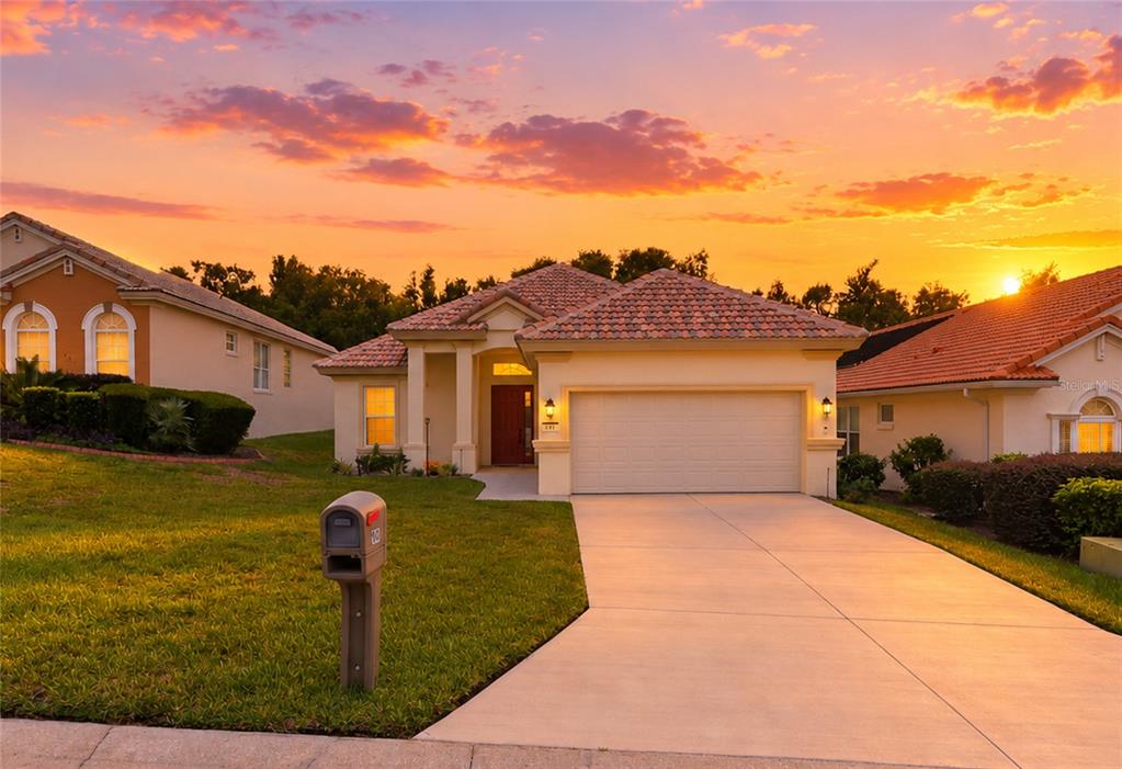 A single-story house with a tiled roof, two-car garage, and a concrete driveway at sunset — 191 W DOERR PATH, HERNANDO, FL