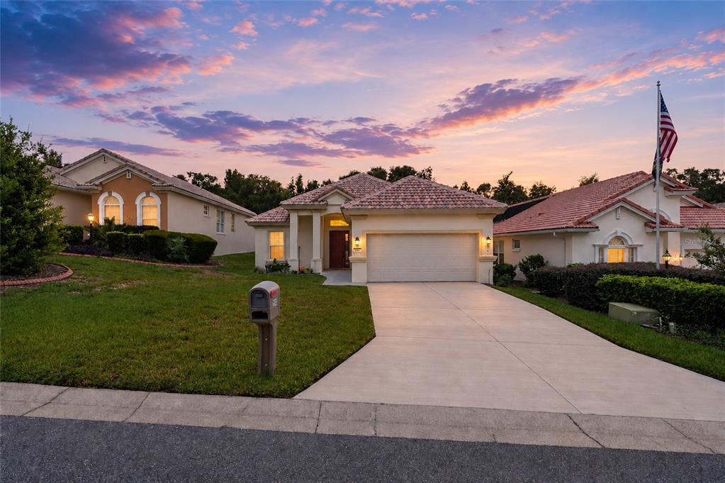 A single-story house with a tile roof, two-car garage, and a concrete driveway at sunset — 191 W DOERR PATH, HERNANDO, FL