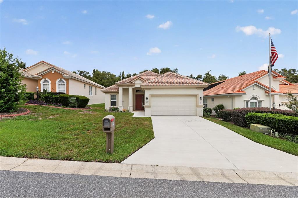 A single-story suburban house with a tile roof, two-car garage, and a concrete driveway — 191 W DOERR PATH, HERNANDO, FL
