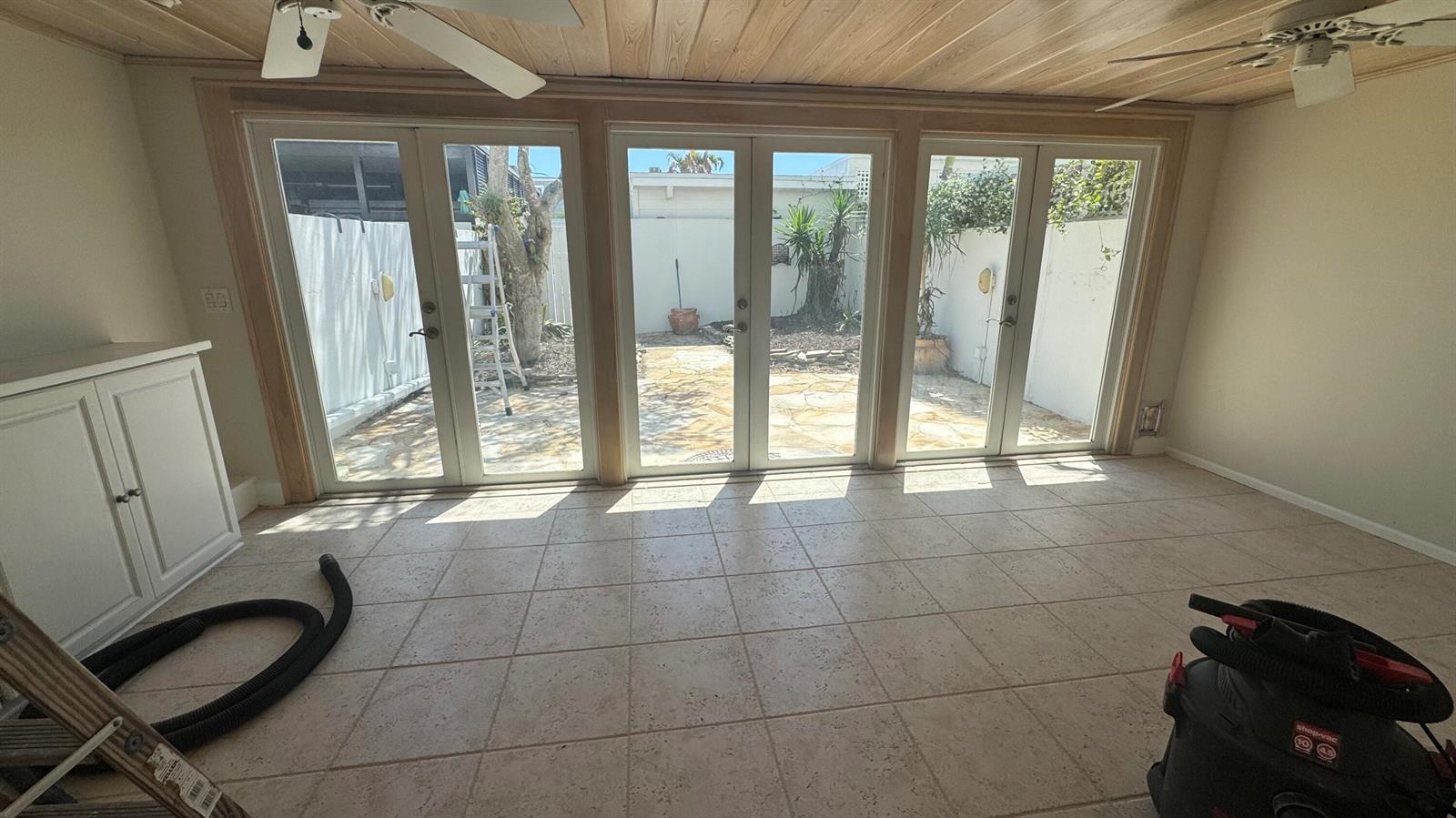 A sunroom features tile flooring, a wood-paneled ceiling, and three sets of glass French doors — 2704 Cardinal Drive, Vero Beach FL 32963, VERO BEACH, FL