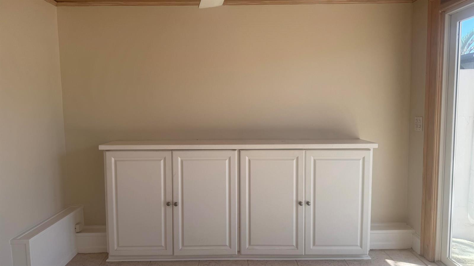 A room features a white four-door cabinet against a beige wall near a glass door — 2704 Cardinal Drive, Vero Beach FL 32963, VERO BEACH, FL