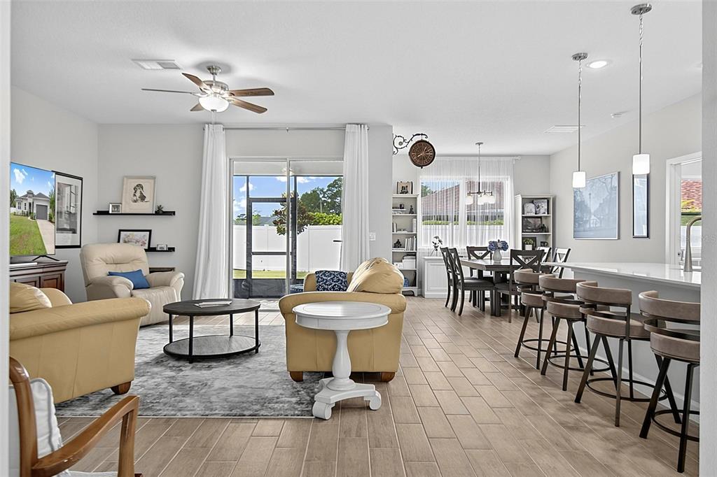 An open-concept living and dining area features tile flooring, neutral walls, and a kitchen island — 30 POPLAR DRIVE, PALM COAST, FL