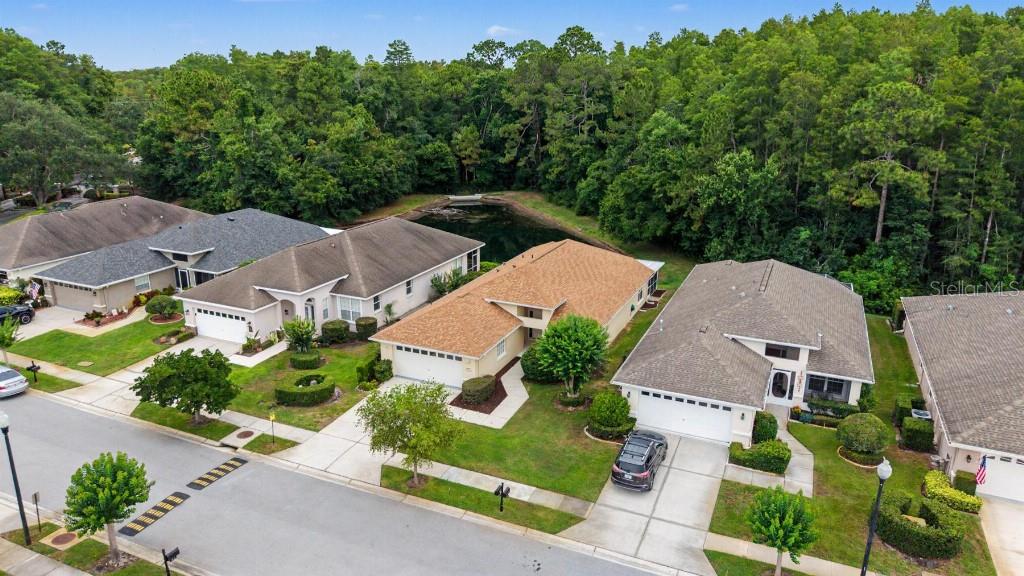 An aerial view shows a row of suburban houses with driveways and a small pond behind — 1812 ORCHARDGROVE AVENUE, NEW PORT RICHEY, FL