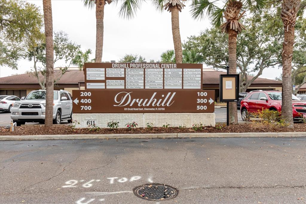 A brown directory sign for the Druhill Professional Center stands in a parking lot — 611 DRUID ROAD E UNIT 707 & 708, CLEARWATER, FL