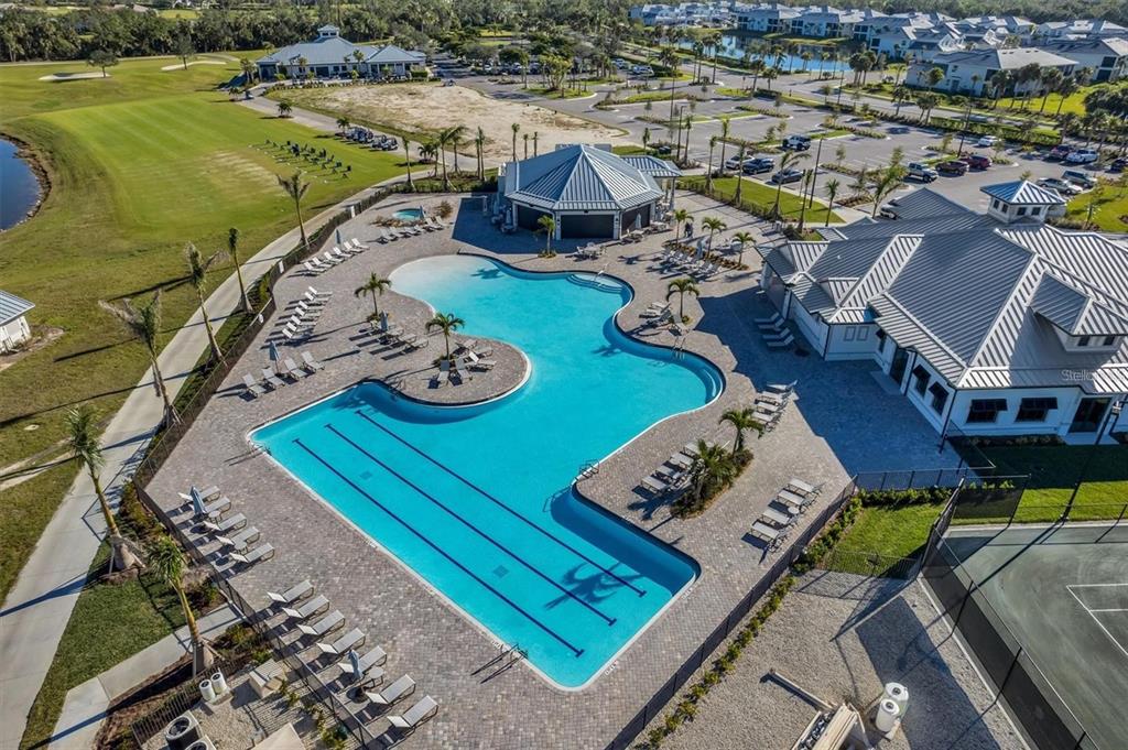 An aerial view shows a community swimming pool with lap lanes, lounge chairs, and buildings — 14121 HERITAGE LANDING BOULEVARD UNIT 725, PUNTA GORDA, FL