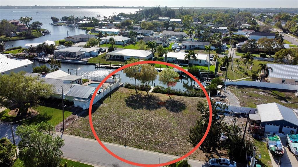 An aerial view shows a vacant waterfront lot with two trees and a small dock — 907 22ND AVENUE W, PALMETTO, FL