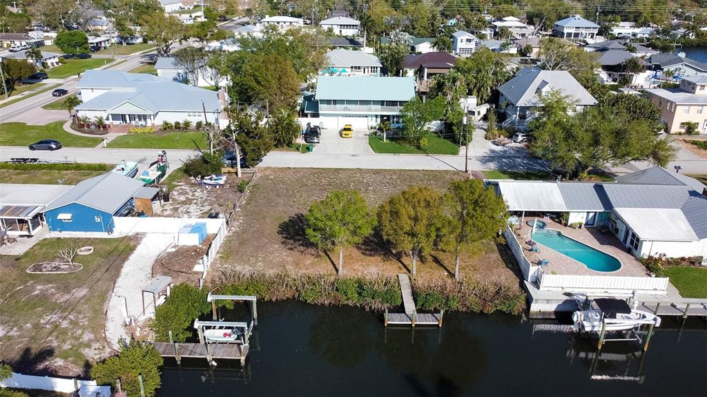An aerial view shows a vacant waterfront lot situated between two houses with private docks — 907 22ND AVENUE W, PALMETTO, FL