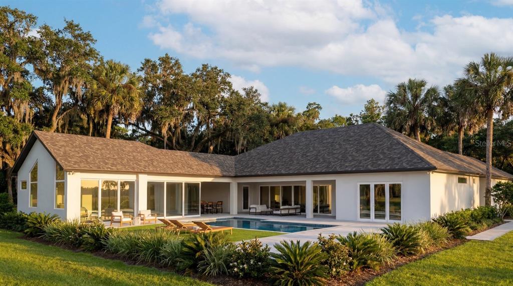 A white single-story house with a swimming pool and patio surrounded by trees and grass — 3654 HIDDEN RIVER LANE, TAVARES, FL