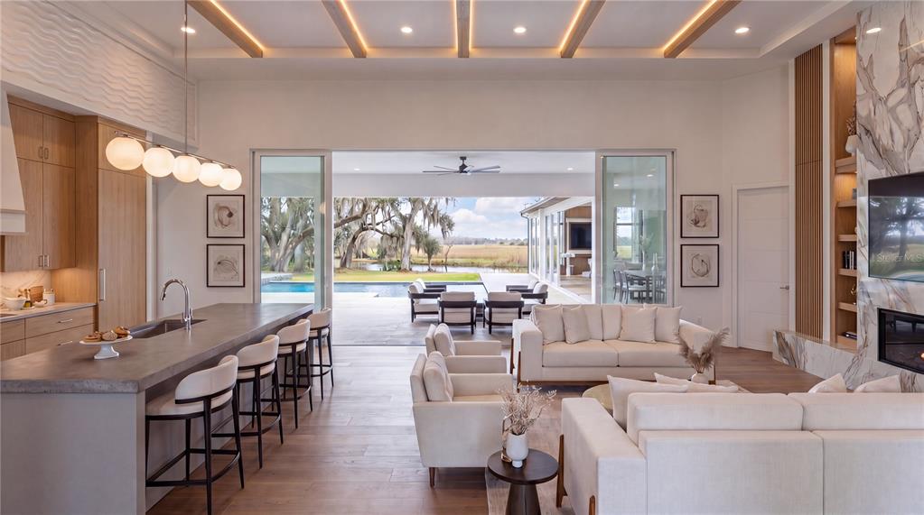 This rendering shows a modern outdoor patio with a pool, lounge seating, and dining area — 3654 HIDDEN RIVER LANE, TAVARES, FL