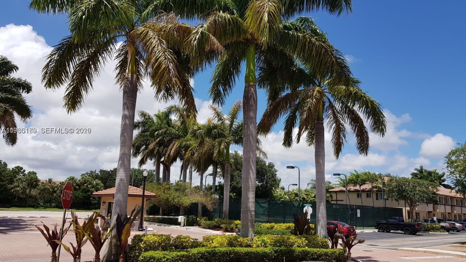 Tall palm trees stand in front of a gated entrance with a stop sign — 3525 Sonoma Dr, Riviera Beach FL 33404, RIVIERA BEACH, FL